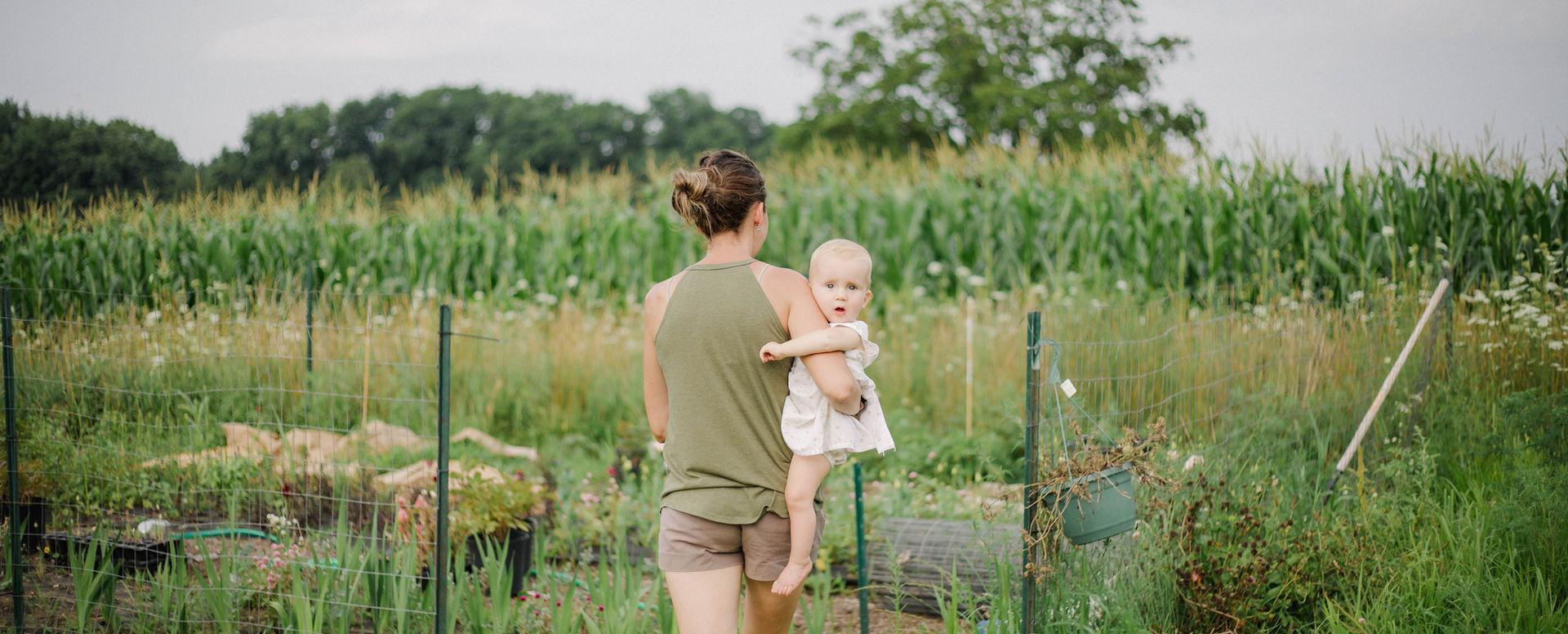 Sarah walking through the flower garden with her daughter